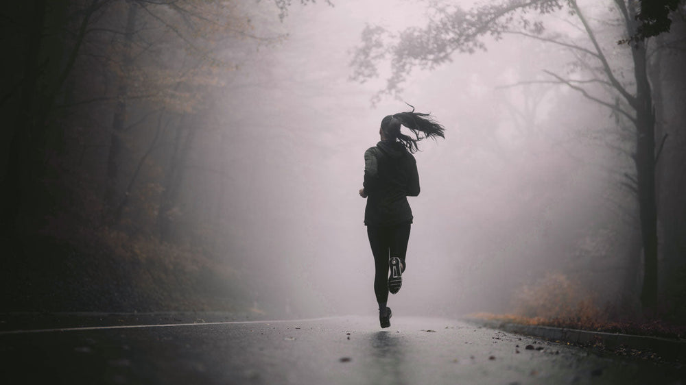 Joggerin auf Straße im Wald