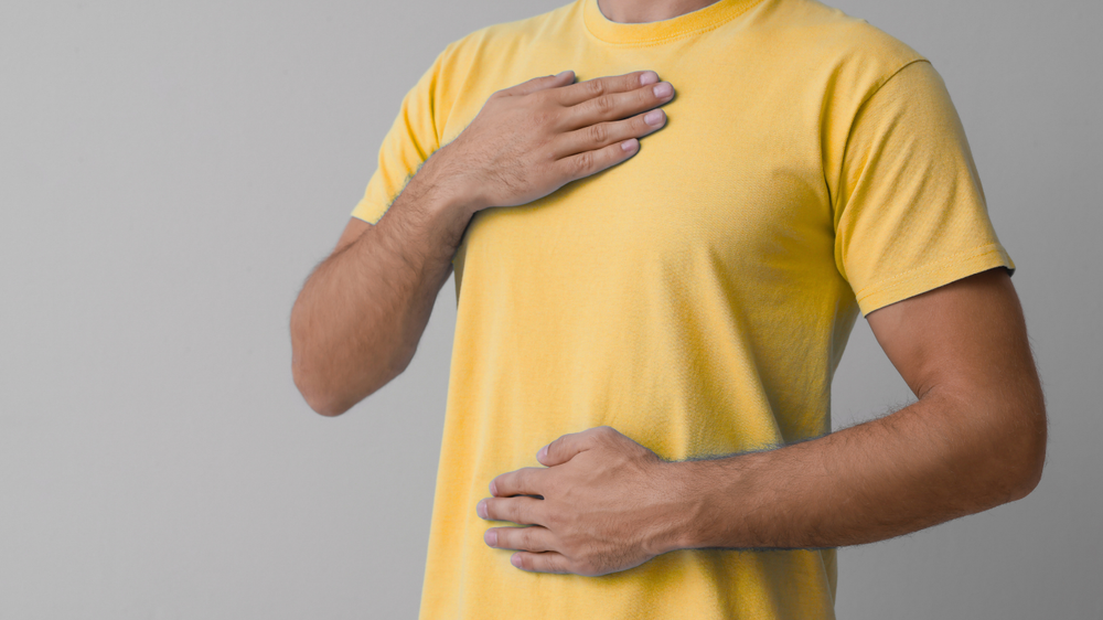 Person mit gelbem T-Shirt mit Atemübung