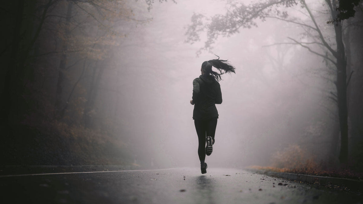 Joggerin auf Straße im Wald