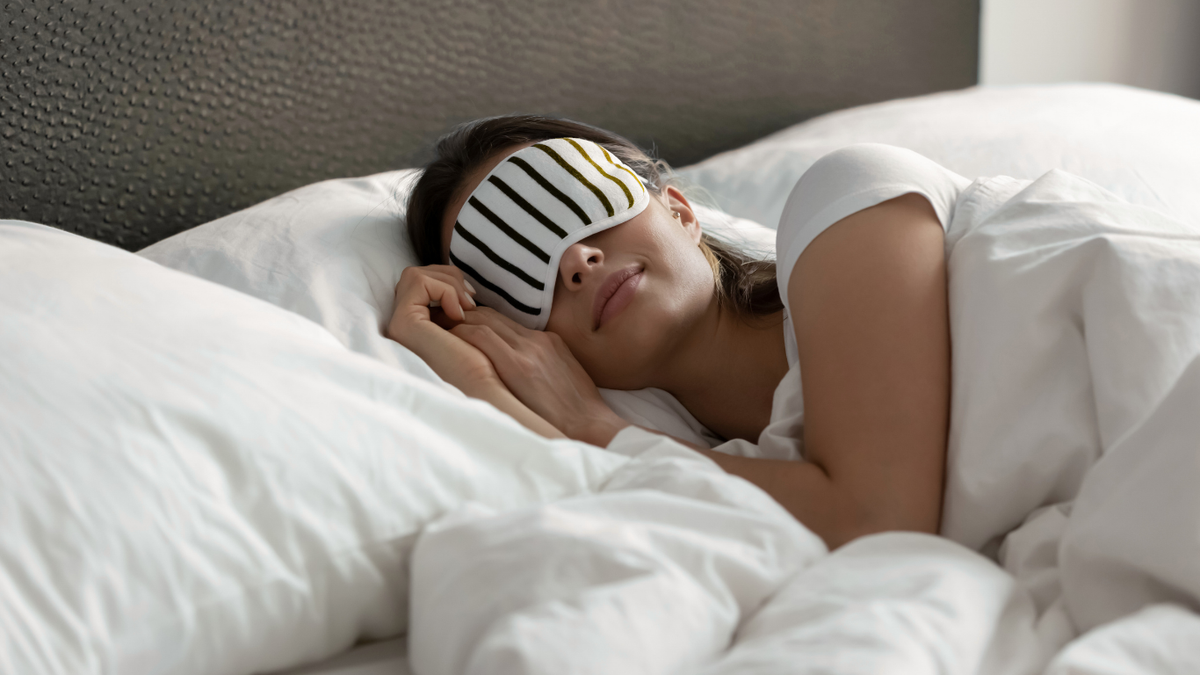 Frau mit Schlafmaske im Bett