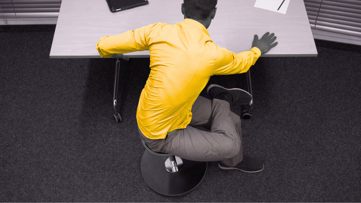 Mann im Büro mit gelbem Hemd beim Stretching